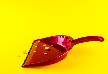 Pink dust pan with shiny golden Heart shape stickers on yellow background.