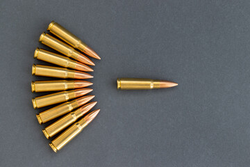 Bullets on gray paper background, one bullet ahead of the rest. Cartridges 7.62 caliber for...