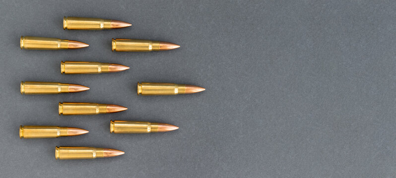 Bullets On Gray Paper Background. Cartridges 7.62 Caliber For Kalashnikov Assault Rifle, Template Banner With Copy Space