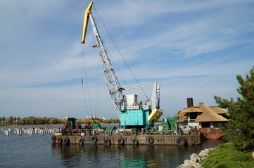 A crane used for construction and loading goods near water.