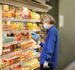 Supermarket shopping, face mask and gloves,Young man shopping in supermarket, reading product information