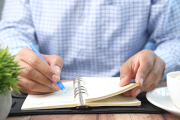 Close up of man hand writing on notepad.
