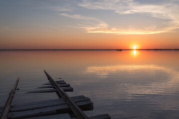 Fototapeta na wymiar sunset lake clouds rails reflection salt horizon