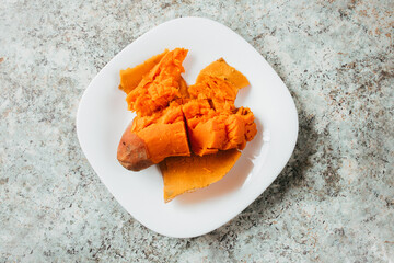 Boiled and hot sweet potato on white plate