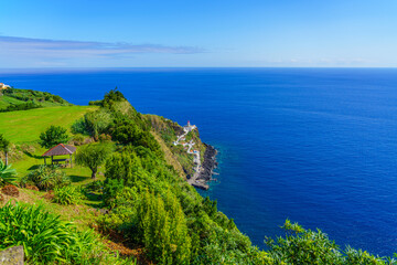 Fototapeta na wymiar Landscape with the Lighthouse Ponta do Arnel near Nordeste town in Sao Miguel, Azores