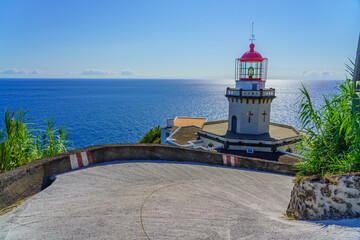 Fototapeta na wymiar The Lighthouse Ponta do Arnel with street near Nordeste town in Sao Miguel