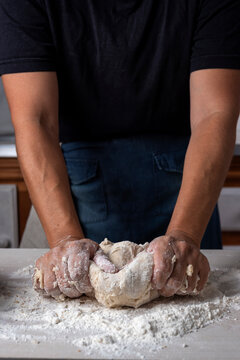 hands kneading croissants and croissants on wooden countertop