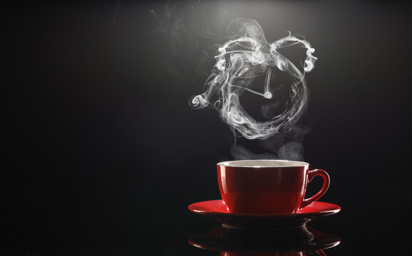 Cup of hot coffee and steam in shape of alarm clock on dark background