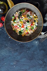 Rice salad with vegetables and tuna. Top view with copy space. Healthy food.
