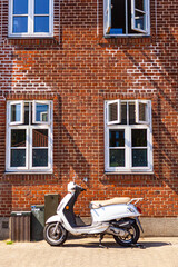 White Scooter Parked on Sidewalk