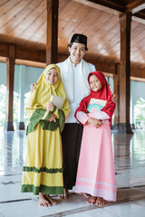Portrait of an Muslim teacher and Muslim children holding the al quran book in a mosque