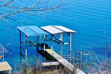 Wooden pier, boat lifts and hoists in waterfront residential neighborhood on the Seneca Lake, New York 