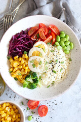 Rice salad with vegetables and sesame on light background. Top view with copy space. Healthy eating.