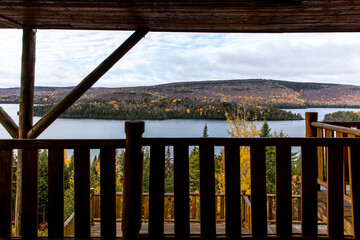 vue de la rive de l'autre côté d'un lac à partir d'un balcon en bois une journée ennuagée
