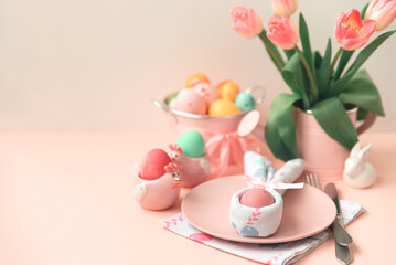 Festive Easter table setting with napkin Easter Bunny on pink table. Easter celebration concept. Soft focus. Copy space