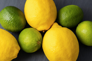 Fresh lemon and lime fruits on dark slate background