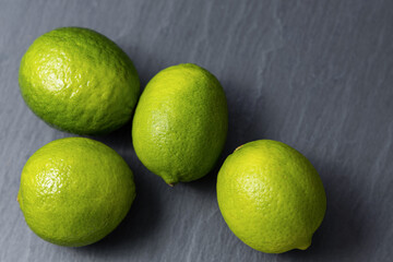 Fresh lime fruits on dark slate background