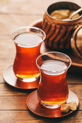 Glasses of tasty Turkish tea and bowl with sugar on wooden background