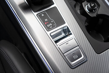 Detail of a parking brake in a modern car interior. Electronic parking brake button in a modern...