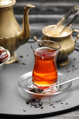 Glass of tasty Turkish tea on dark background