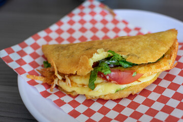a fried quesadilla with cheese and pork cheese on a napkin, typical food from venezuela, mexico and latin america.