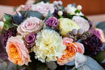Beautiful bouquet of vintage flowers. Roses, carnationon and leaves on dark background.