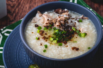 Arroz caldo, also spelled Aroskaldo- is a Filipino rice and chicken gruel heavily infused with ginger and garnished with toasted garlic, scallions, and black pepper (close up)