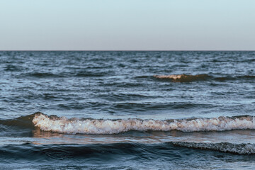 small sea waves in the sea on a clear warm day. Summer vacation near the water