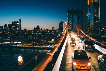 Illuminated New York skyline and traffic on Manhattan bridge