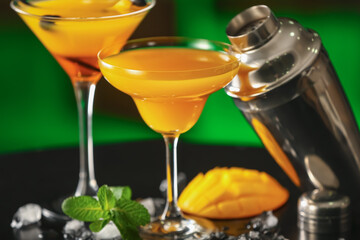Tasty mango cocktails on color background, closeup