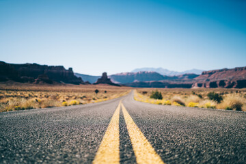 Fototapeta na wymiar Long empty asphalt road in dry valley in USA
