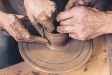 Training for work in the potter's wheel. A man and a woman work together with clay.