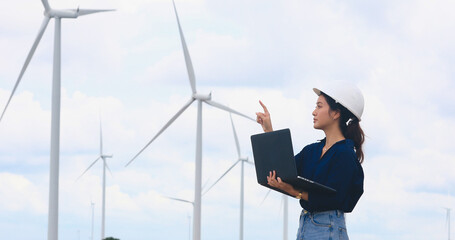 Women engineer using tablet for working on site at wind turbine farm