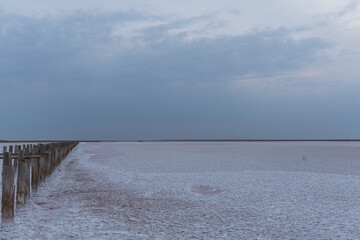 Obraz premium Wooden posts in a pink lake. The pink water of the lake. Beautiful views while relaxing