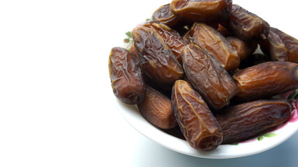 Close up photo of dates in white background. Ramadan conceptual photo. Fasting conceptual photo. Copy space.