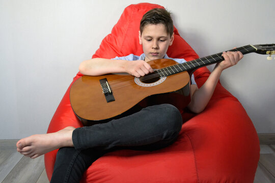 close up boy playing the guitar