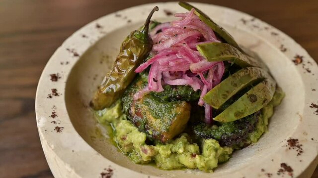 Fishbowl in green sauce with guacamole, chili peppers and nopal.
