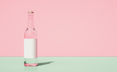 Glass beer bottle on horizontally divided bi-color retro pastel pink and green color background.