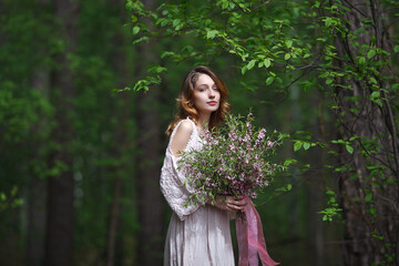 beautiful girl in a pink lace dress walks in the park with a bouquet of pink flowers, bride in boho style