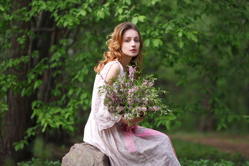 beautiful girl in a pink lace dress walks in the park with a bouquet of pink flowers, bride in boho style