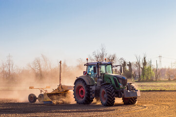Fototapeta premium Tractor working in the field, preparing the land for planting