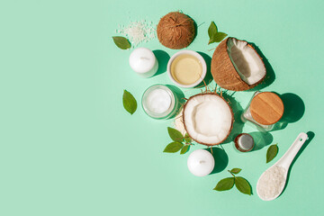 Natural coconut cosmetics on a blue background. Contrasting shadows trend. Spa treatments, cream, oil, coconut and sea salt