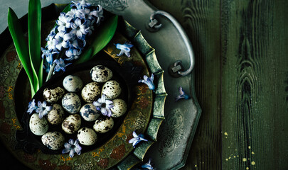 Easter background with Easter eggs and spring flowers. Easter composition with eggs on vintage plates.