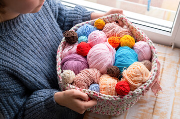Fototapeta na wymiar Woman holding knitted couch with yarn balls
