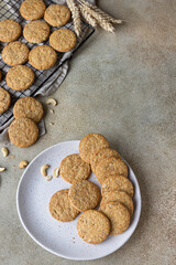 Oatmeal cookies with cereals, seeds and nuts, concrete background. Healthy vegan cookies. Top view.