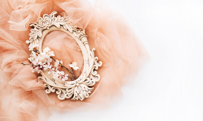 Old oval carved frame with spring flowers and leaves on pastel background. Spring flowers composition with copy space.