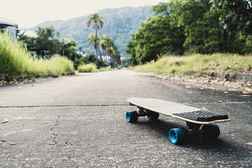 Longboard or skateboard on the road and pathway in park. Outdoor activities.