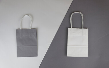 The concept of love of shopping. Two color paper bags for shopping on a paper background. Flat lay. Top view.