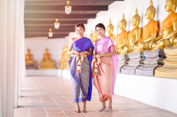 Attractive Thai women in traditional Thai dress hold fresh flower garlands for entering a temple based on the Songkran festival tradition in Thailand
