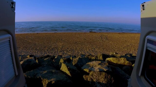Watching the waves break on Omaha beach Normandy France out the back doors of a campervan